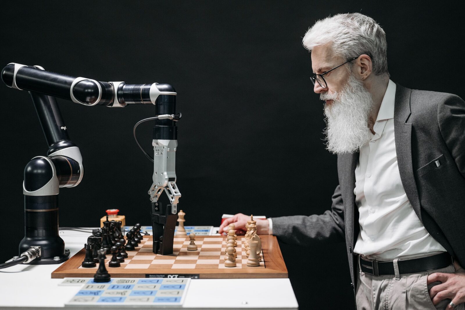 Una persona e un sistema robotico interagiscono davanti a una scacchiera.